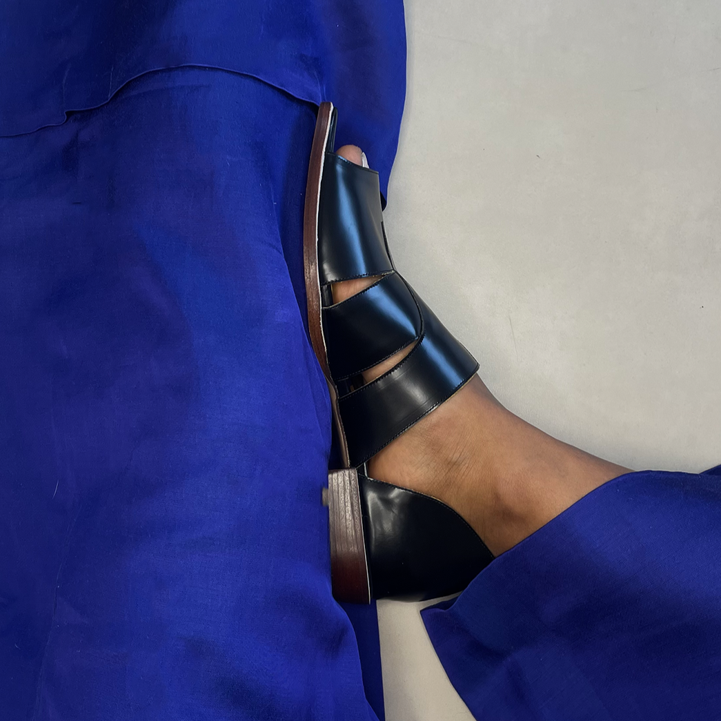 Agatha Black Peep-toe Sandals by Mafalda Handmade worn by model with blue trousers