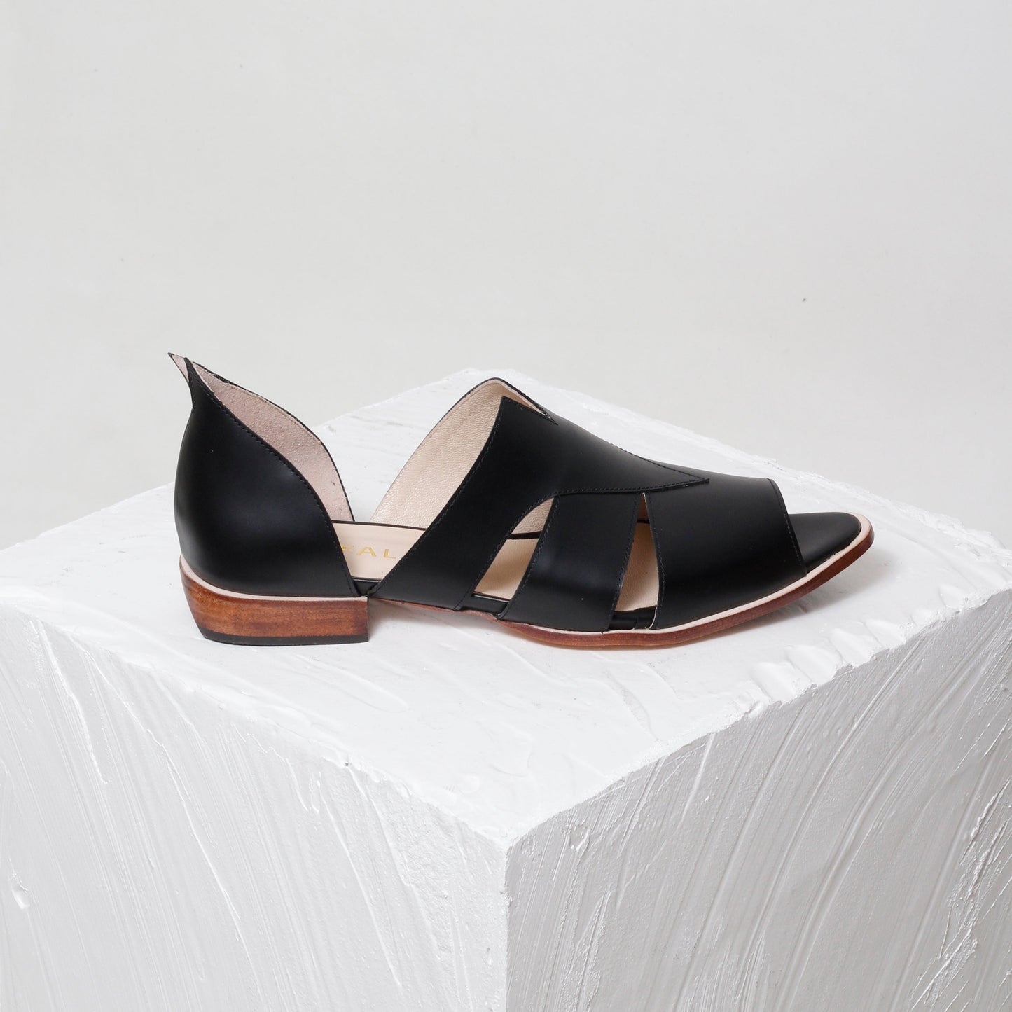 Black sandal with cut-out design on a white background
