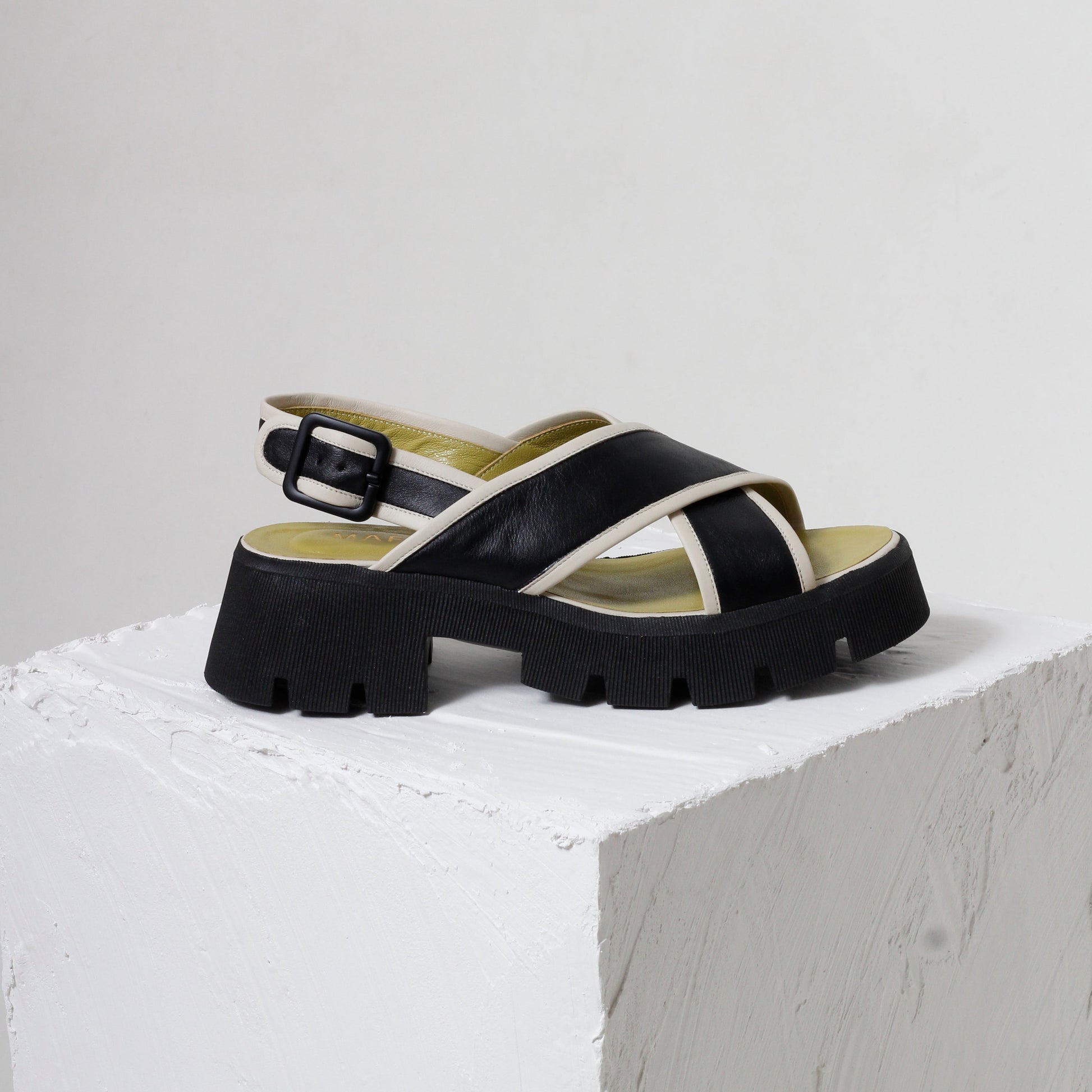 Black and white sandals with lack buckle and green linning detail 