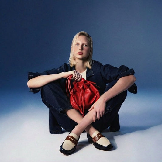 Diana White Black and Brown Penny Loafer by Mafalda Handmade worn by model with jeans trousers and jacket and red drawstring Noa bag