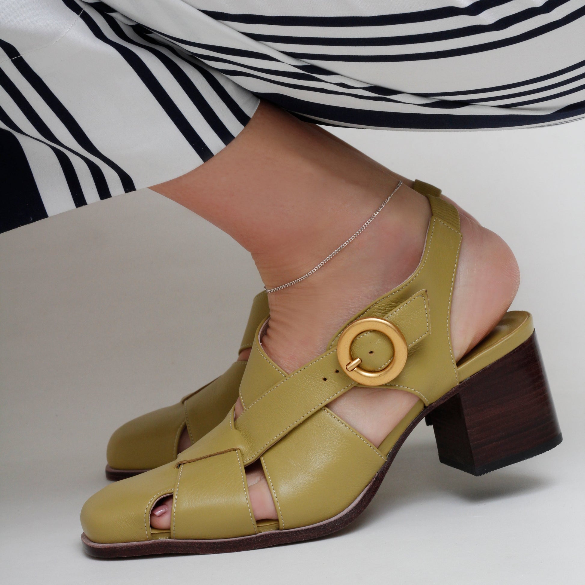 Lucia Green Leather Pumps by Mafalda Handmade worn by model with stripped trousers and side gold buckles