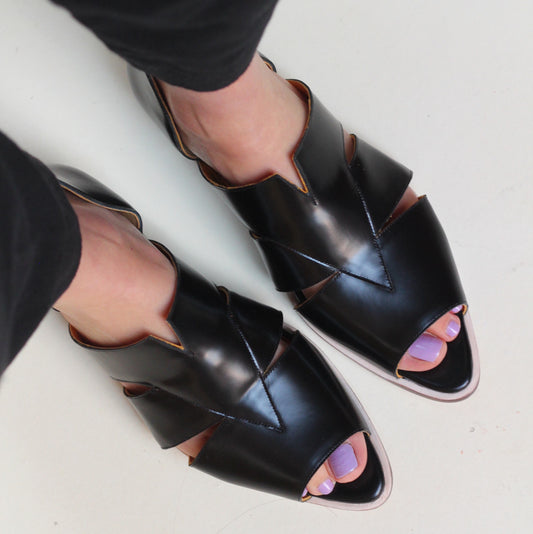 Agatha Black Peep-toe Sandals by Mafalda Handmade worn by model with black trousers and lavender nail polish