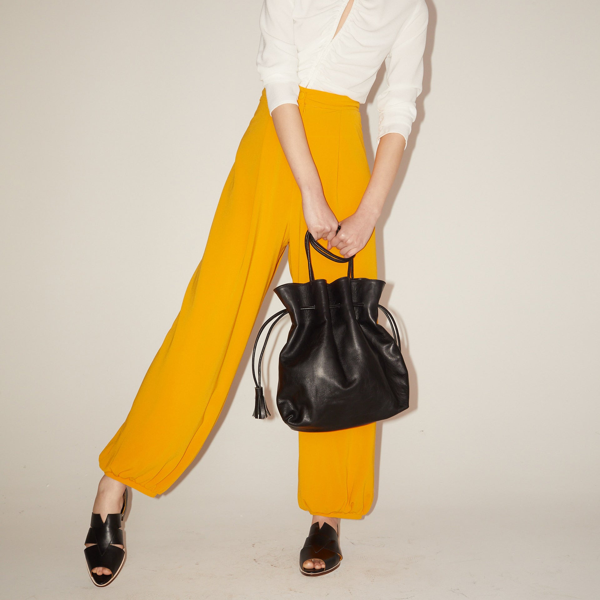 Agatha Black Peep-toe Sandals by Mafalda Handmade worn by model wearing yellow trousers and white shirt